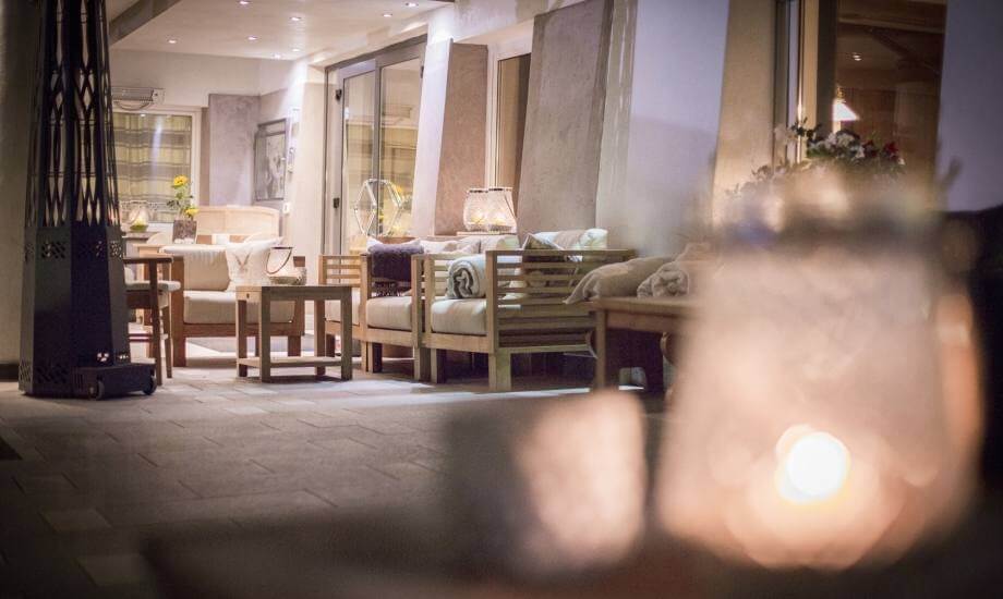 Una stanza accogliente con un camino, scrivania, poltrone e decorazioni eleganti in toni terrosi.