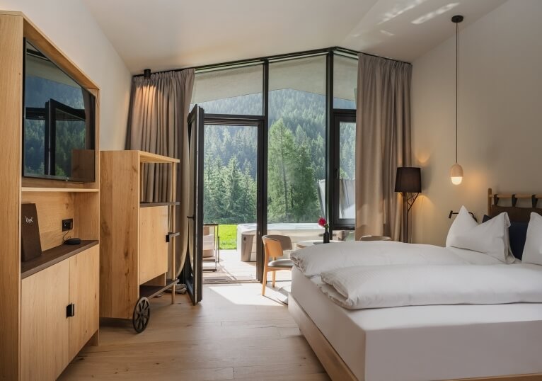Camera d'hotel con letto grande, TV e accesso a un'area esterna.