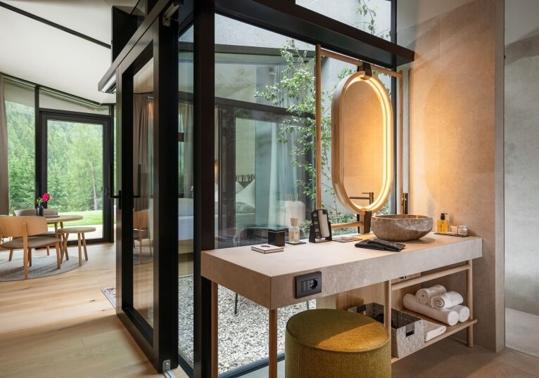 Moderna camera d'hotel con bagno, vanity e area soggiorno.