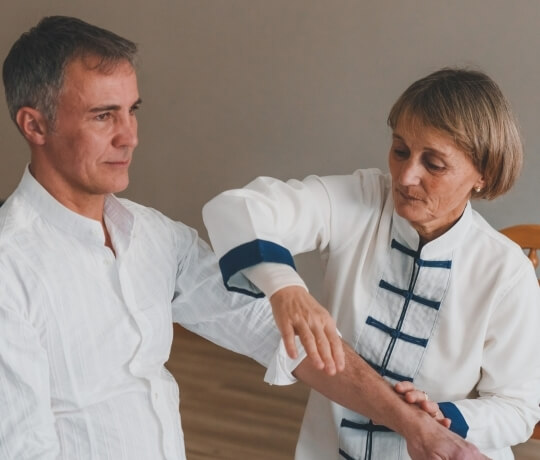 Uomo in camicia bianca e donna in tunica bianca con dettagli blu.