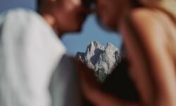 Due persone sfocate con una montagna rocciosa nitida sullo sfondo.