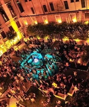 Una vivace folla si riunisce davanti a un grande edificio illuminato, creando un'atmosfera festosa e gioiosa.