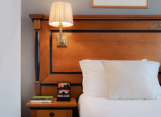 Camera d'hotel con testiera in legno e tavolino accanto al letto.