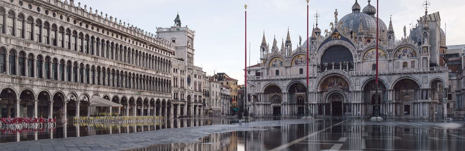 Basilica di San Marco a Venezia, riflessa nell'acqua calma, evidenziando la sua bellezza architettonica e serenità.