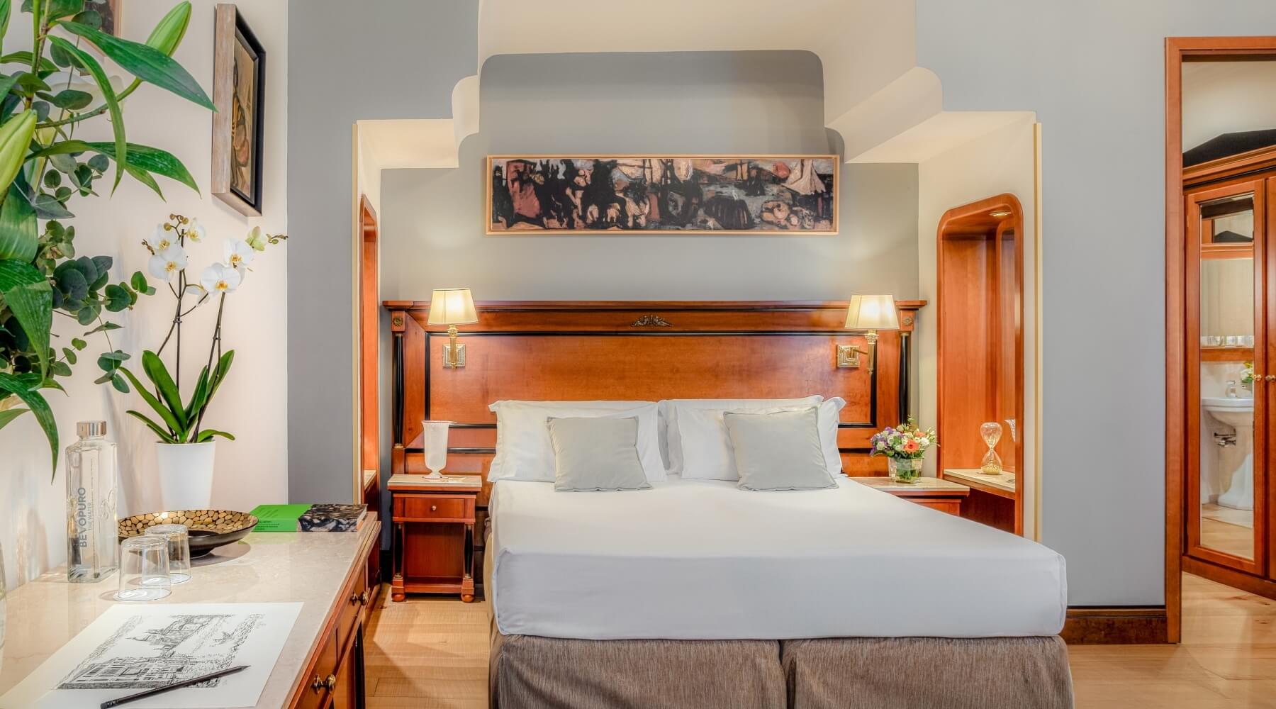 Camera d'albergo elegante con letto grande, scrivania, bagno visibile e decorazioni armoniose.