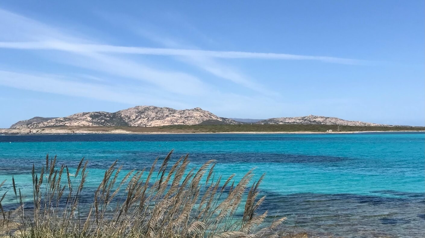 Islands with rocky formations and turquoise water under a blue sky. Isole con formazioni rocciose e acqua turchese sotto un cielo blu.