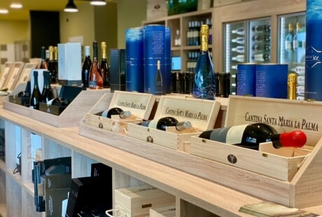 Esposizione di vini in casse di legno con scatole blu.