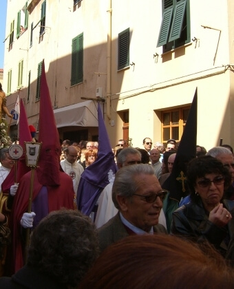 Persone in abiti cerimoniali e casual si riuniscono all'aperto.