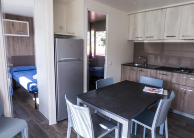 Cucina con tavolo e camera da letto adiacente.