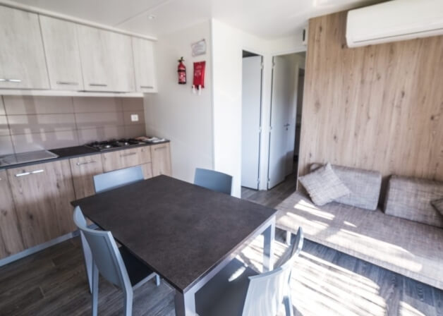 Cucina con tavolo, divano e attrezzature di sicurezza antincendio.