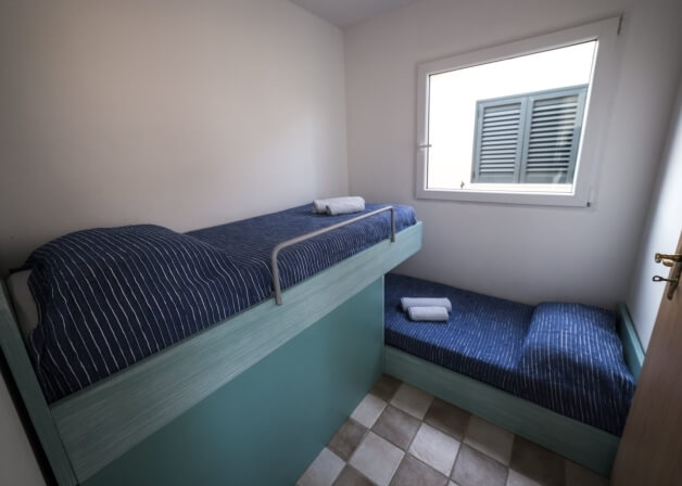 Camera con due letti a castello e pareti bianche.