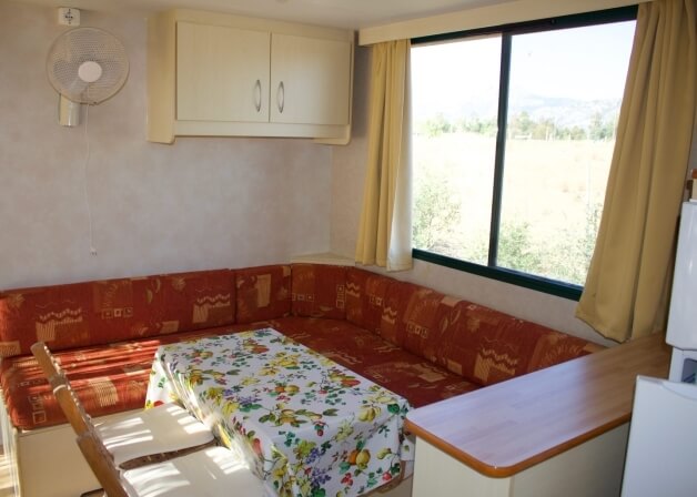 Divano rosso con tavolo floreale e vista panoramica.