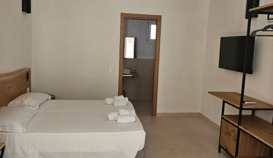 Camera d'hotel con letto, bagno e unità TV.