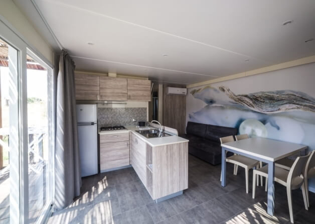 Spazio abitativo con cucina, zona pranzo e area salotto moderna.