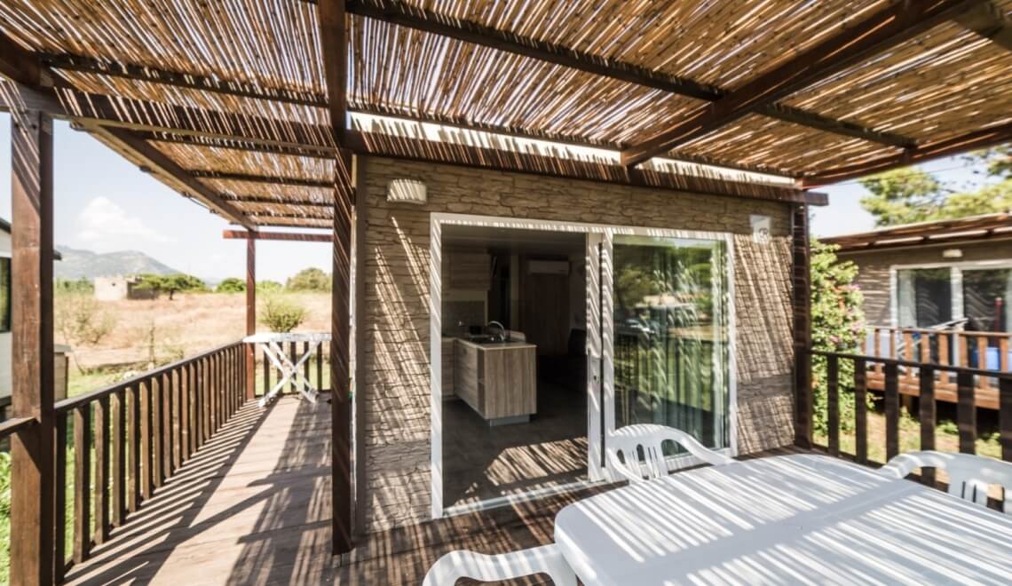 Area pranzo all'aperto su un deck con strutture moderne.