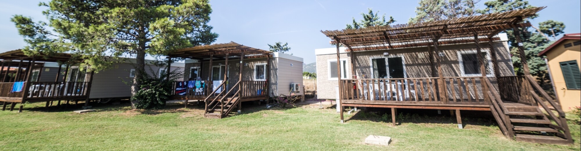 Case mobili con verande in legno su un'area verde.