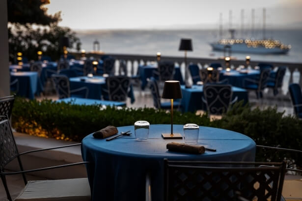 tavolo per cena con barca in mare sullo sfondo