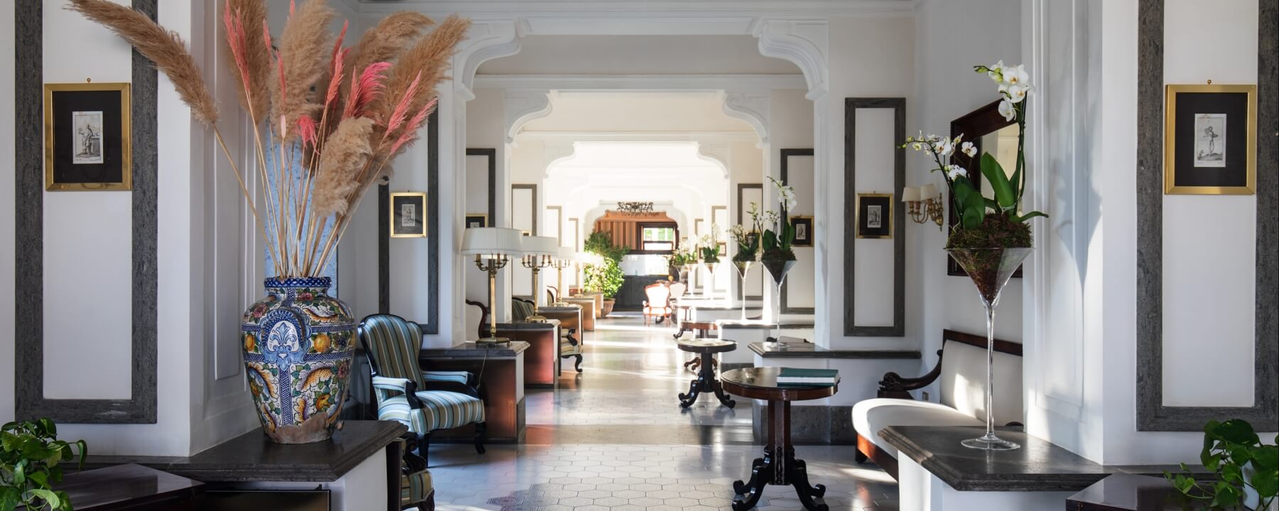 corridoio con molti punti luce e vasi con fiori ai lati