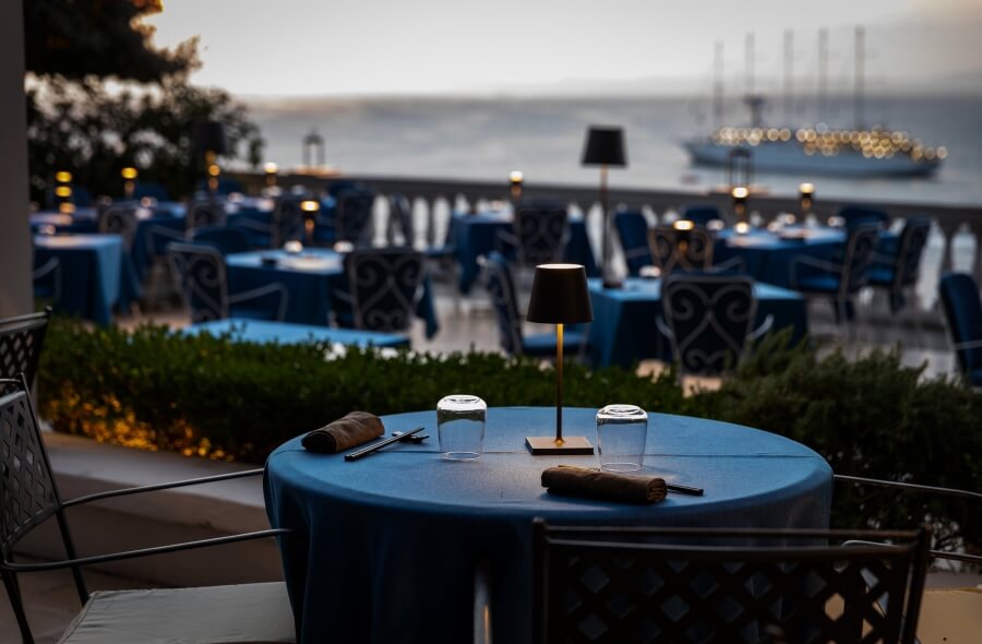 tavolo per cena con barca in mare sullo sfondo