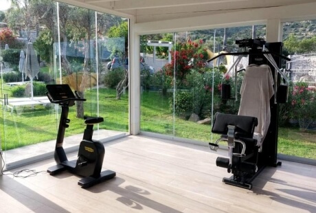 Heller Fitnessraum im Cruccùris Resort mit Blick ins Grüne. Ein funktionaler, bewusst reduzierter Raum für Bewegung ohne Leistungsdruck oder Trainingszwang.