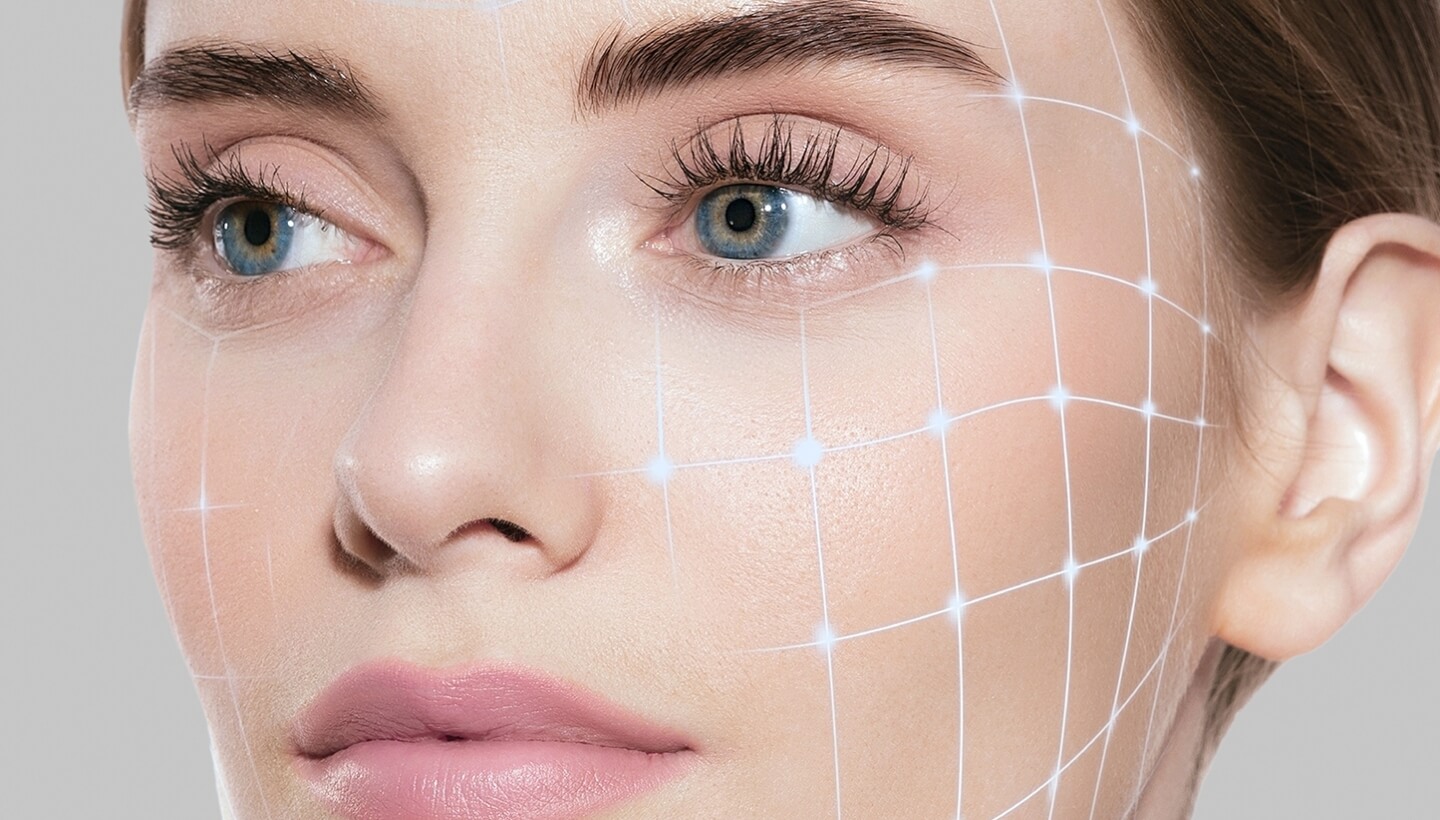 Close-up of a woman's face with blue eyes and digital grid overlay.   Primo piano di un volto femminile con occhi blu e griglia digitale.