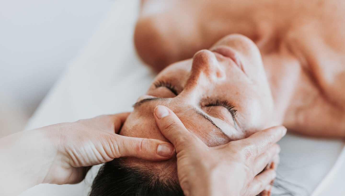 Close-up of a person relaxing during a forehead massage.