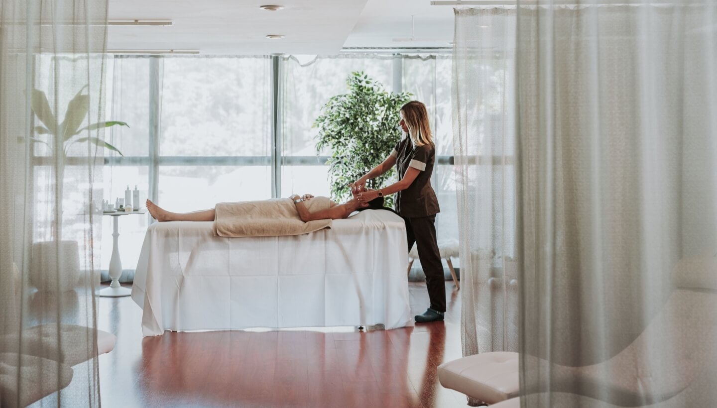 Spa room with a person receiving a massage on a table.