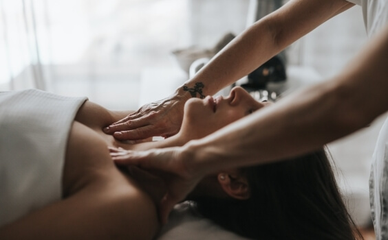 Person receives a massage, covered by a towel, with blurred background.   Eine Person erhält eine Massage, mit Handtuch bedeckt, unscharfer Hintergrund.