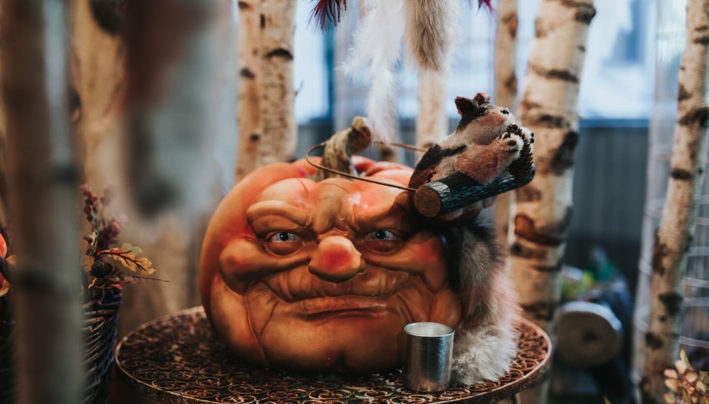 Zucca decorativa con faccia intagliata e scoiattolo di peluche.