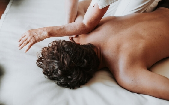 Person erhält eine Massage, während der Masseur den Ellbogen einsetzt.