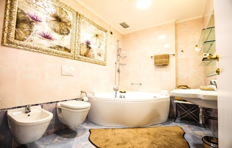 Badezimmer mit runder Badewanne, Bidet, Toilette und Waschbecken.