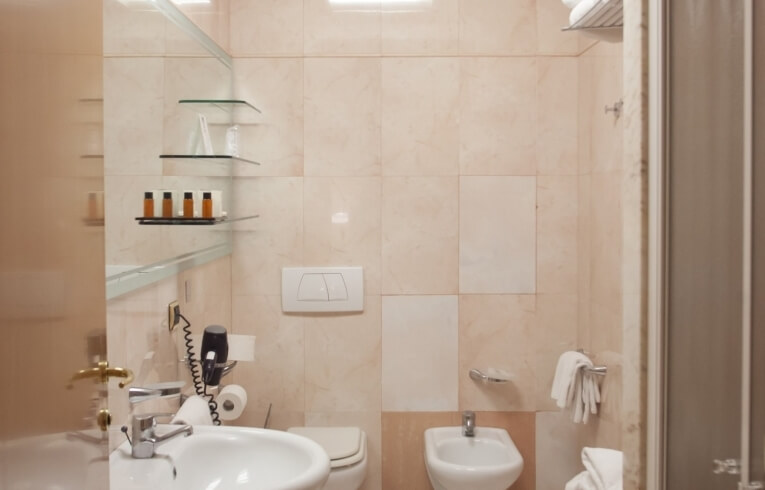 Hotel bathroom featuring a sink, toilet, bidet, and toiletries.