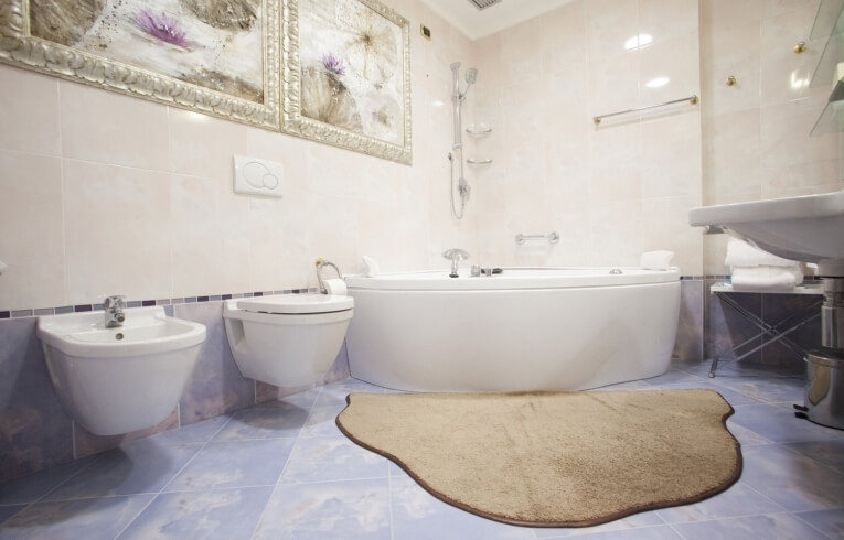 Badezimmer mit Bidet, Toilette, Badewanne und weißen Handtüchern.