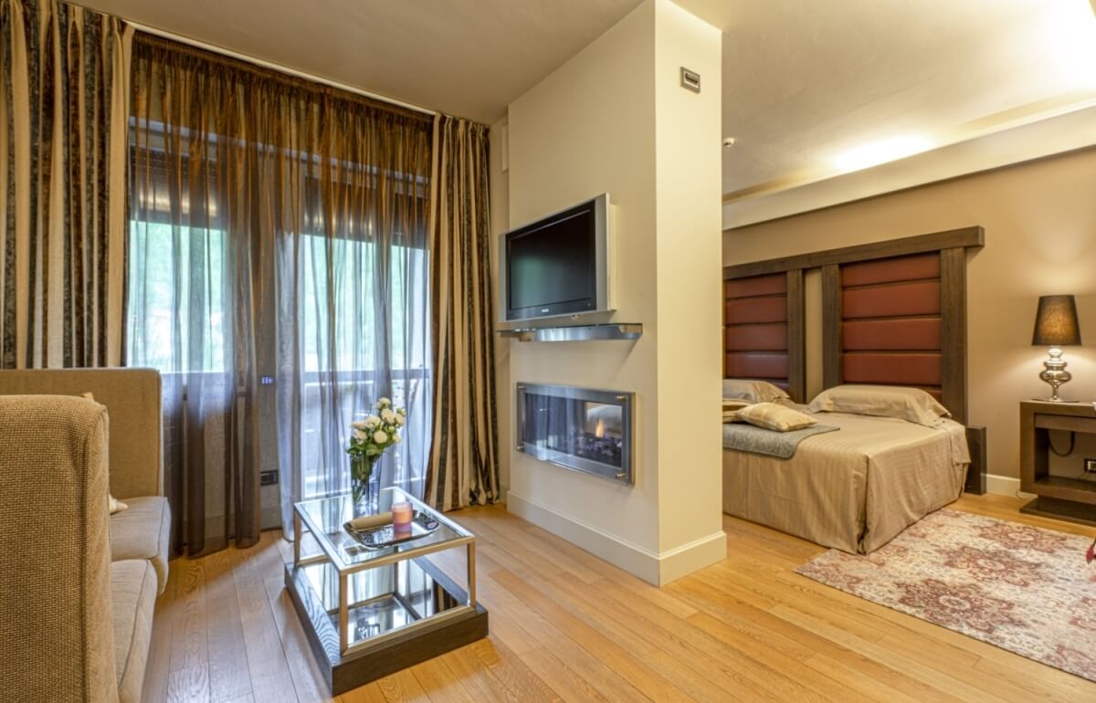 Camera d'hotel con letto, area salotto e camino.