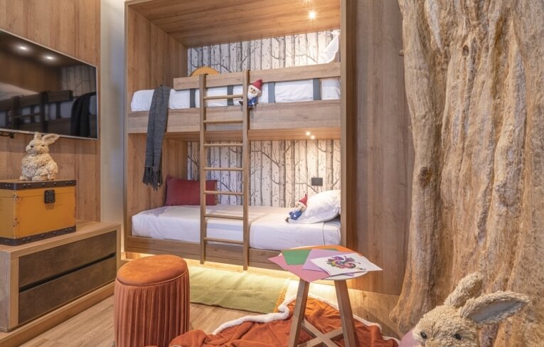 Camera d'hotel con letto a castello e decorazioni a tema natura.