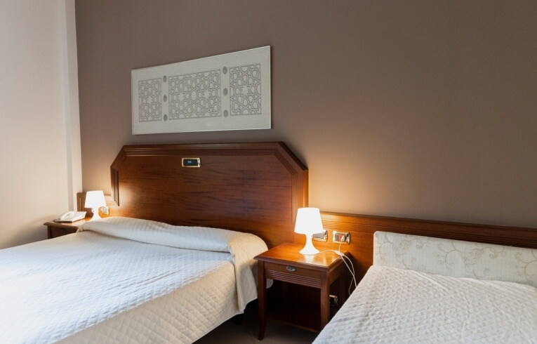 Camera d'hotel con due letti e decorazioni in bianco e marrone.