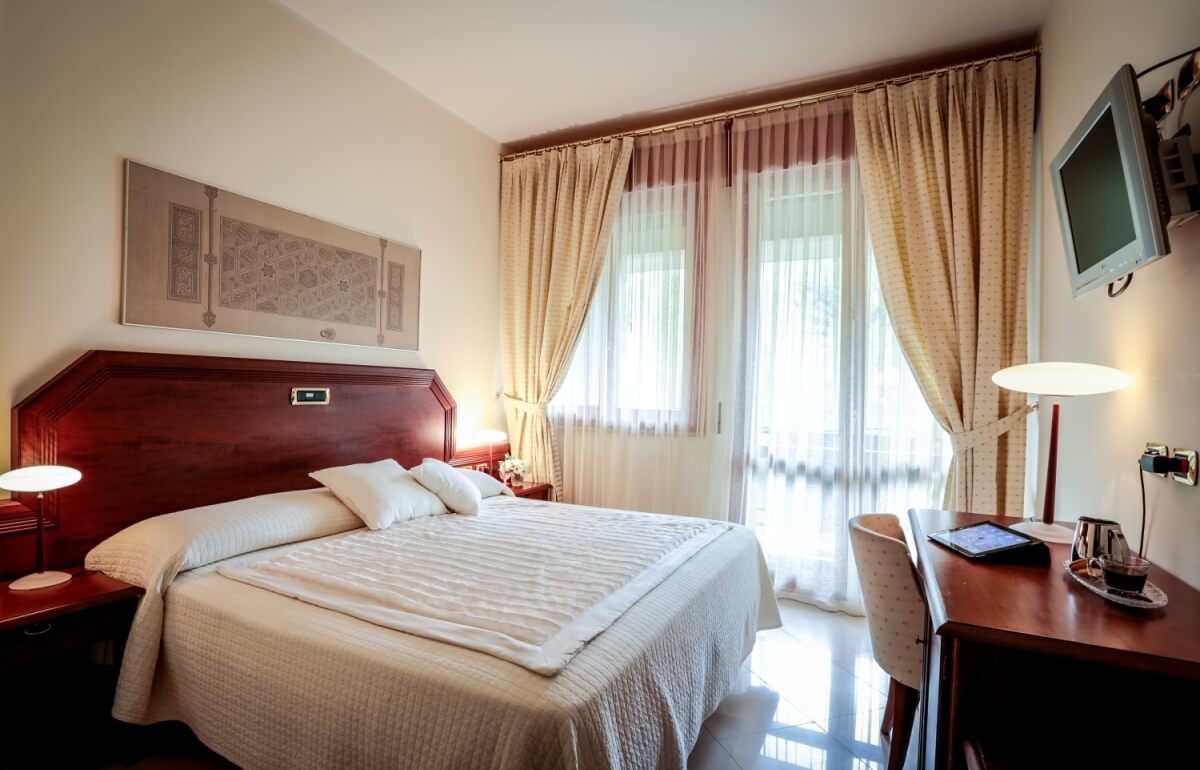 Camera d'hotel con letto, scrivania, TV e caffè.