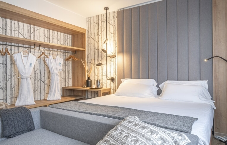 Camera d'hotel con letto, divano e decorazioni eleganti.