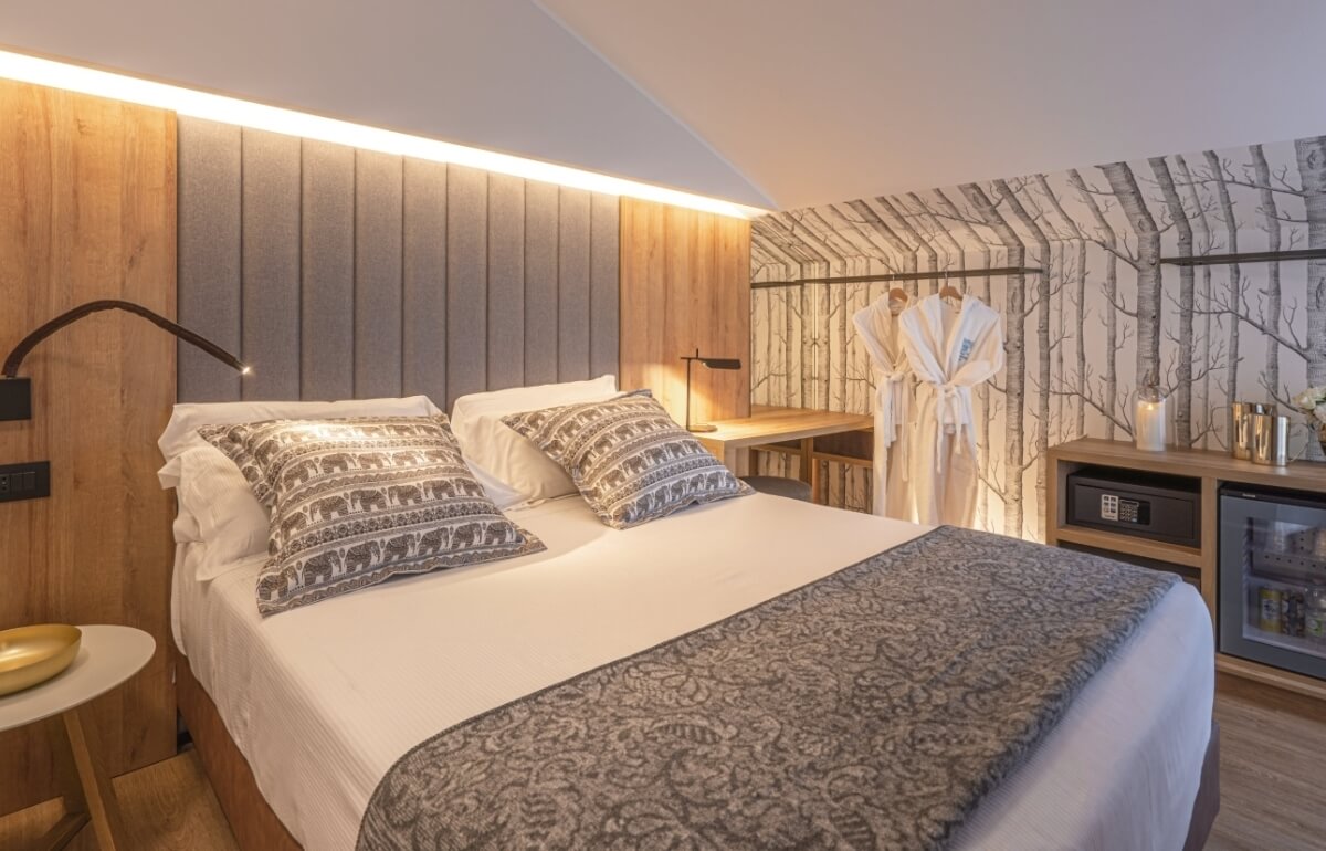 Camera d'hotel con letto, scrivania e decorazioni eleganti.