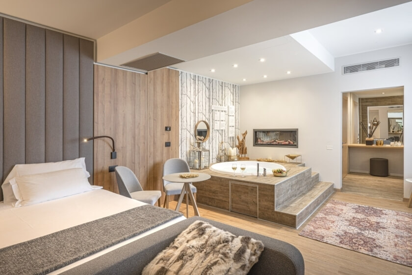 Suite d'hotel con letto, vasca, camino e area vanità.