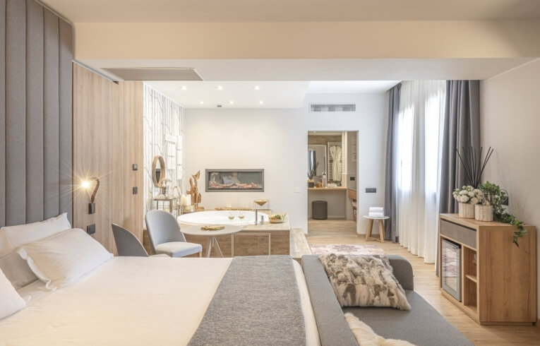 Camera d'hotel con letto, area salotto, camino e bagno.