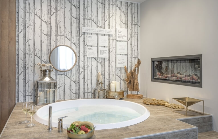 Bagno con vasca circolare, vino, frutta e camino elettrico.