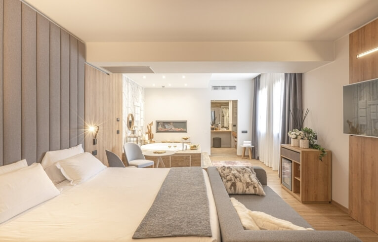 Camera d'hotel con letto grande, divano e area bagno.
