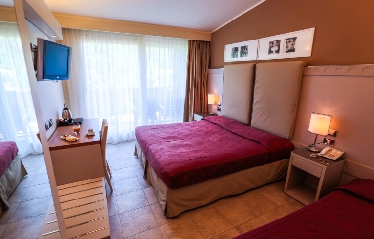 Hotelzimmer mit zwei Betten, Schreibtisch, Fernseher und Snacks.