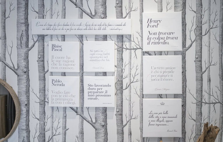 Parete decorata con citazioni e motivo di alberi in bianco e nero.