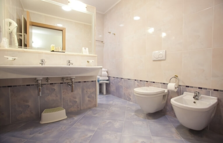 Bagno d'hotel con doppio lavabo, specchio grande e bidet.
