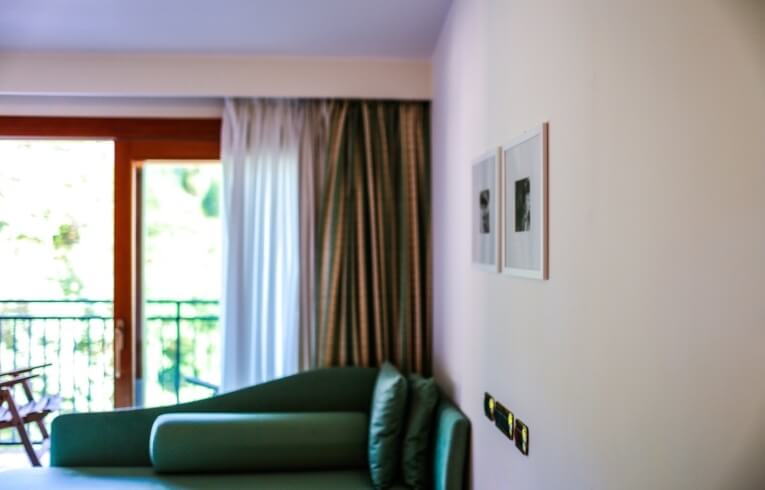 Chaise lounge verde con porte in vetro e tende a strisce.