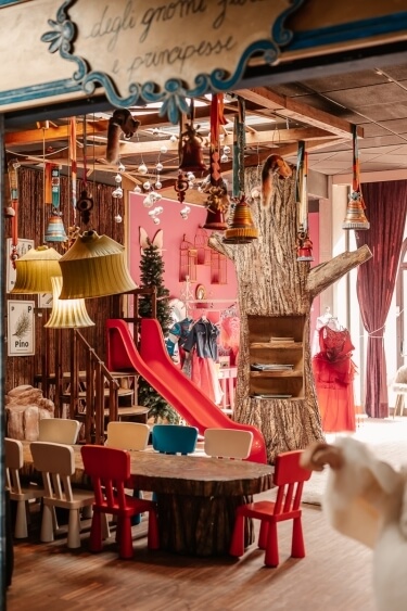 Area giochi colorata con scivolo, tavolo e decorazioni vivaci.