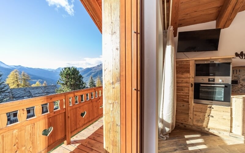 Split-screen of a cozy cabin: left shows a whimsical deck with mountain views; right features a warm kitchen with wooden decor.