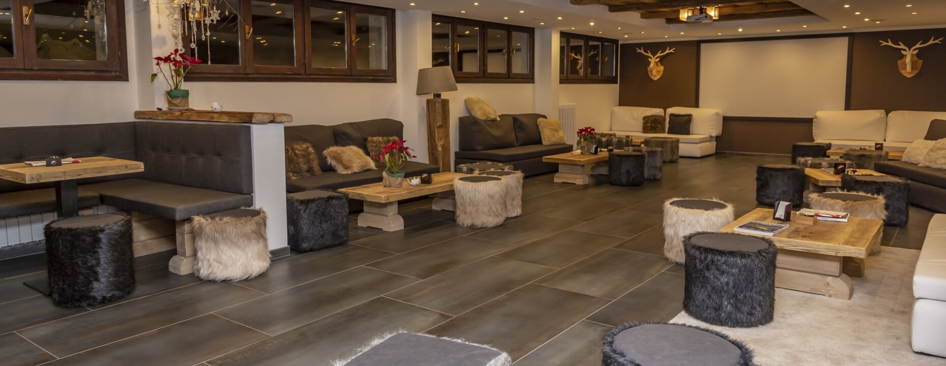 Soggiorno moderno e rustico con divani grigi, mobili in legno chiaro, decorazioni e illuminazione accogliente.